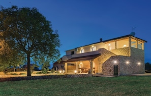 Stunning stone building with a grand staircase and beautifully manicured lawn.