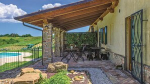 A covered patio with stone pillars, outdoor furniture, and a view of a swimming pool. - Gorgeous home in Barchi PU with private swimming pool, can be inside or outside (Barchi PU)