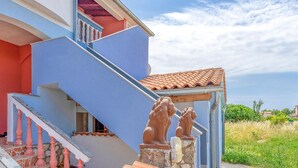 A multi-story building with a blue exterior, a red staircase, and a tiled roof. - 2 bedroom awesome apartment in Vodnjan (Vodnjan)