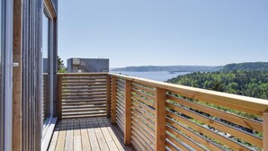 Une terrasse en bois offrant une vue sur un lac et une forêt.