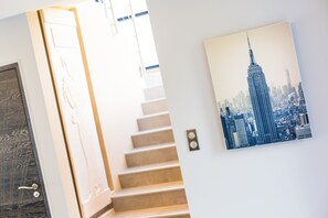 Una scala con un dipinto di un panorama urbano sulla parete.