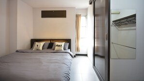 A modern bedroom with a large bed, a wardrobe, and a mirror. - LOFT Salaya (Phutthamonthon)