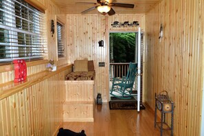 Cozy cabin interior with a bed, rocking chair, and small table.
