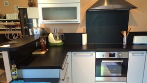 Uma cozinha moderna com forno embutido, micro-ondas e cafeteira.