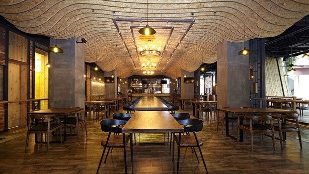 A spacious restaurant with long communal tables and high ceilings. - Merrynest Hotel (Guangzhou)