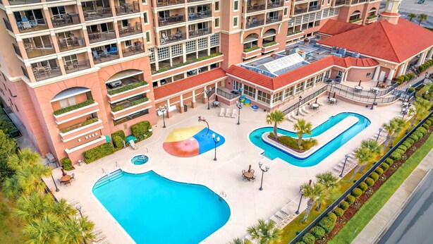 Un hôtel doté d’une grande piscine, de nombreux balcons et d’espaces extérieurs aménagés pour se détendre.