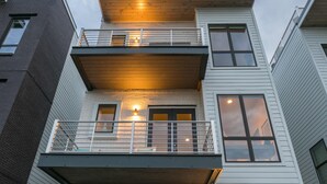 Un immeuble résidentiel à plusieurs étages, doté d’un balcon, d’escaliers et d’une façade en briques.