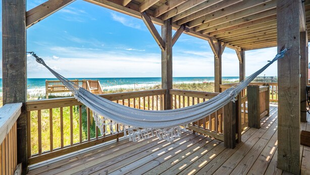 A wooden deck with a hammock and white chairs, overlooking a beach. - Next to Sea Gallery | Group Favorite! Ocean Front + Original Artwork (Topsail Beach)