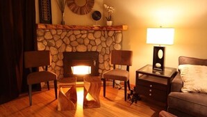 A cozy living room with a stone fireplace, two chairs, a small table with a lamp, and a sofa. - Modern Hotel-Like Luxury! 3 Bed+Loft. Twin Units  Book Separately 329292 (Mammoth Lakes)