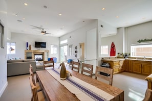 Enjoy a spacious living area with a large dining table and comfortable seating, a well-equipped kitchen with stove and ample storage.