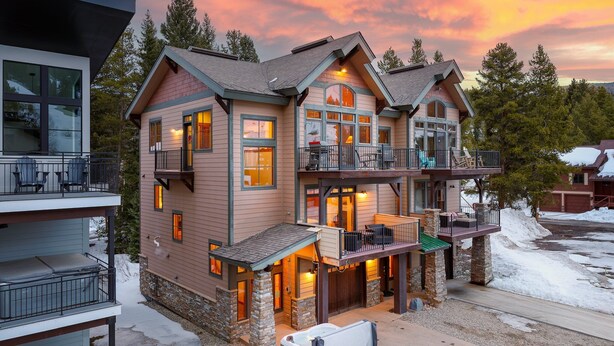 A multi-story house with a balcony, a hot tub, and a deck.