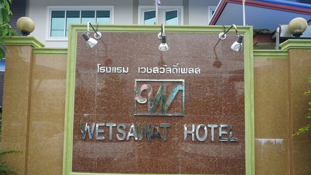 Schild für das Wetsawat Hotel mit Logo und thailändischem Text.