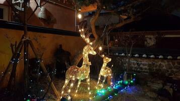 A decorative outdoor scene with illuminated reindeer figures and string lights.