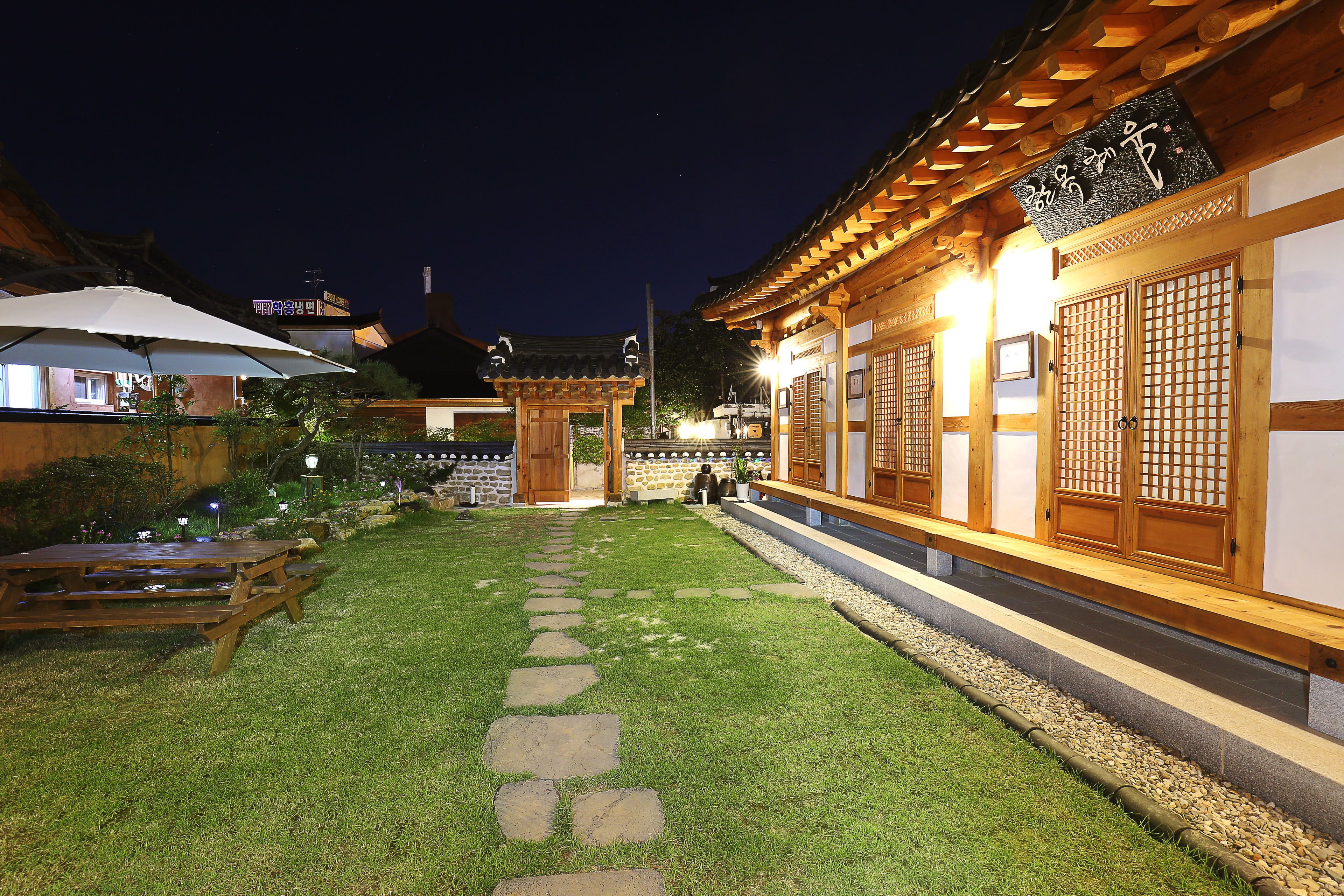 Un edificio japonés tradicional con un sendero de piedra que conduce a una entrada de madera.