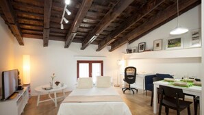 Une chambre à coucher comprenant un lit, une table de chevet, une lampe et un bureau avec des chaises.