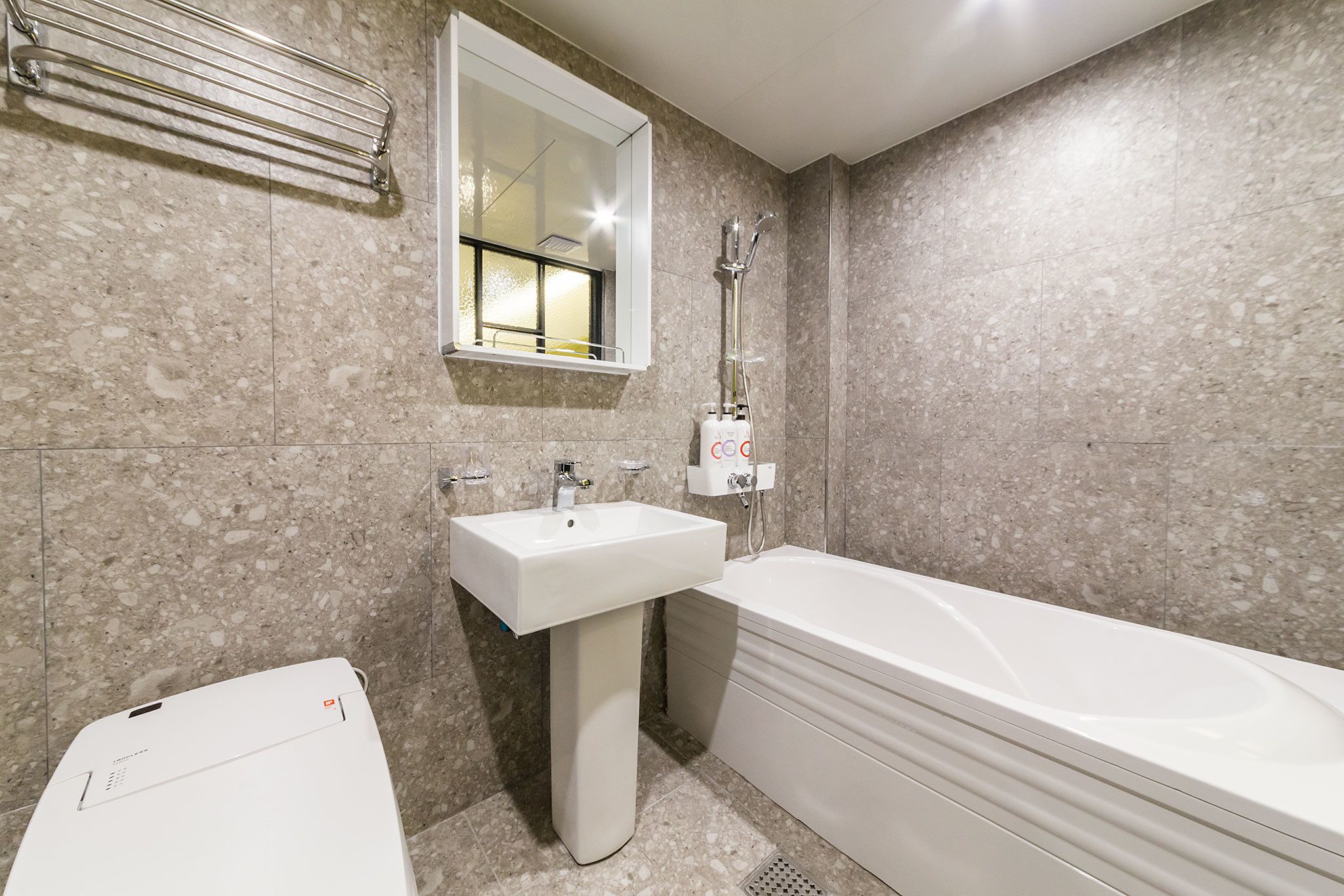 Un baño con lavamanos, espejo y bañera.