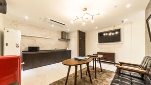 A modern living room with a sofa, a coffee table, and a TV. - Hotel Plum (Siheung)