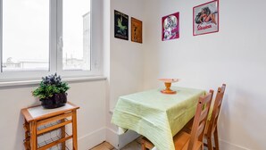A room with a window, a table with a green tablecloth, and three framed pictures on the wall. - Domus Ricca Termini (Rome)