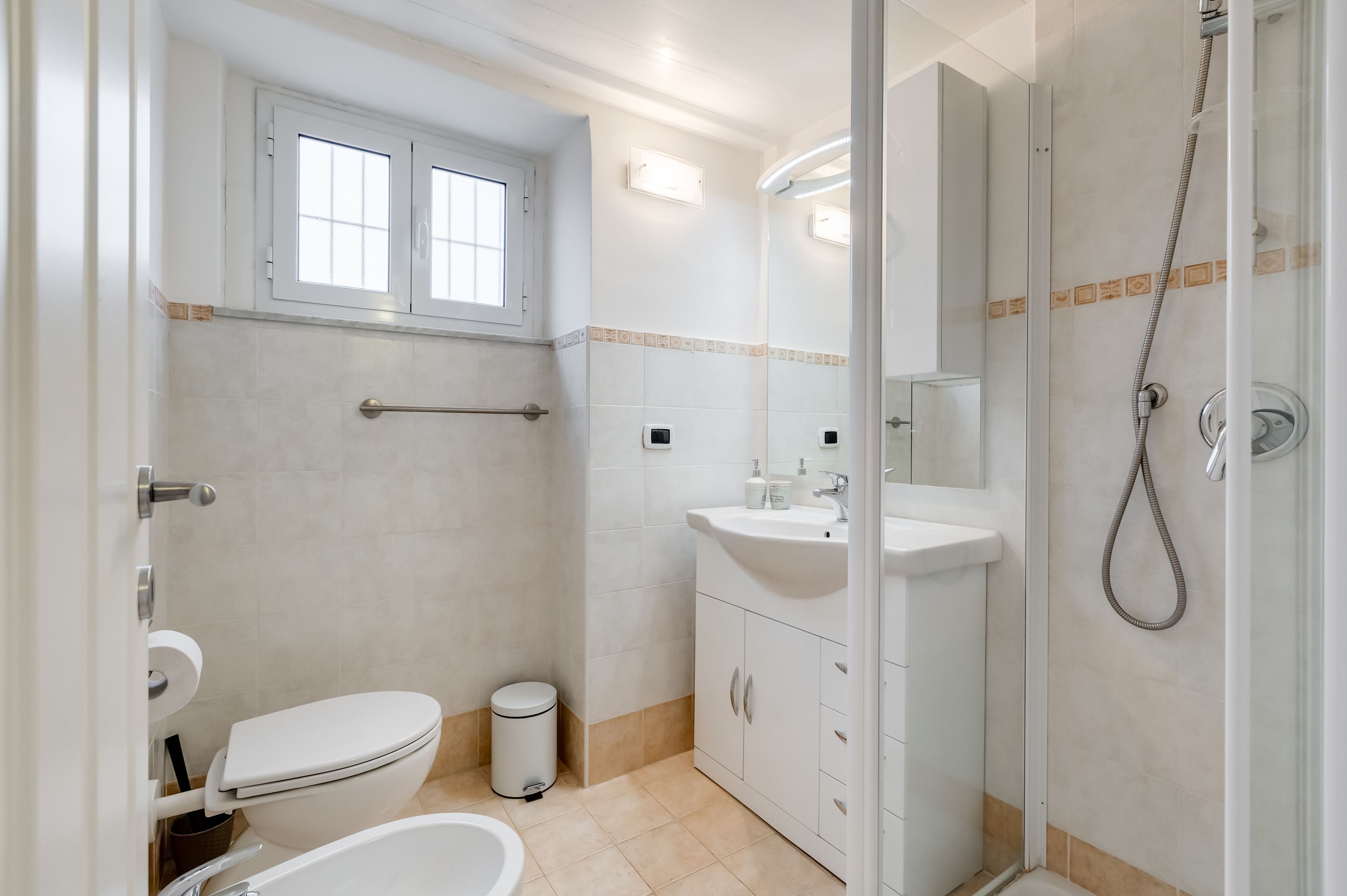 A modern bathroom with a toilet, sink, and shower.