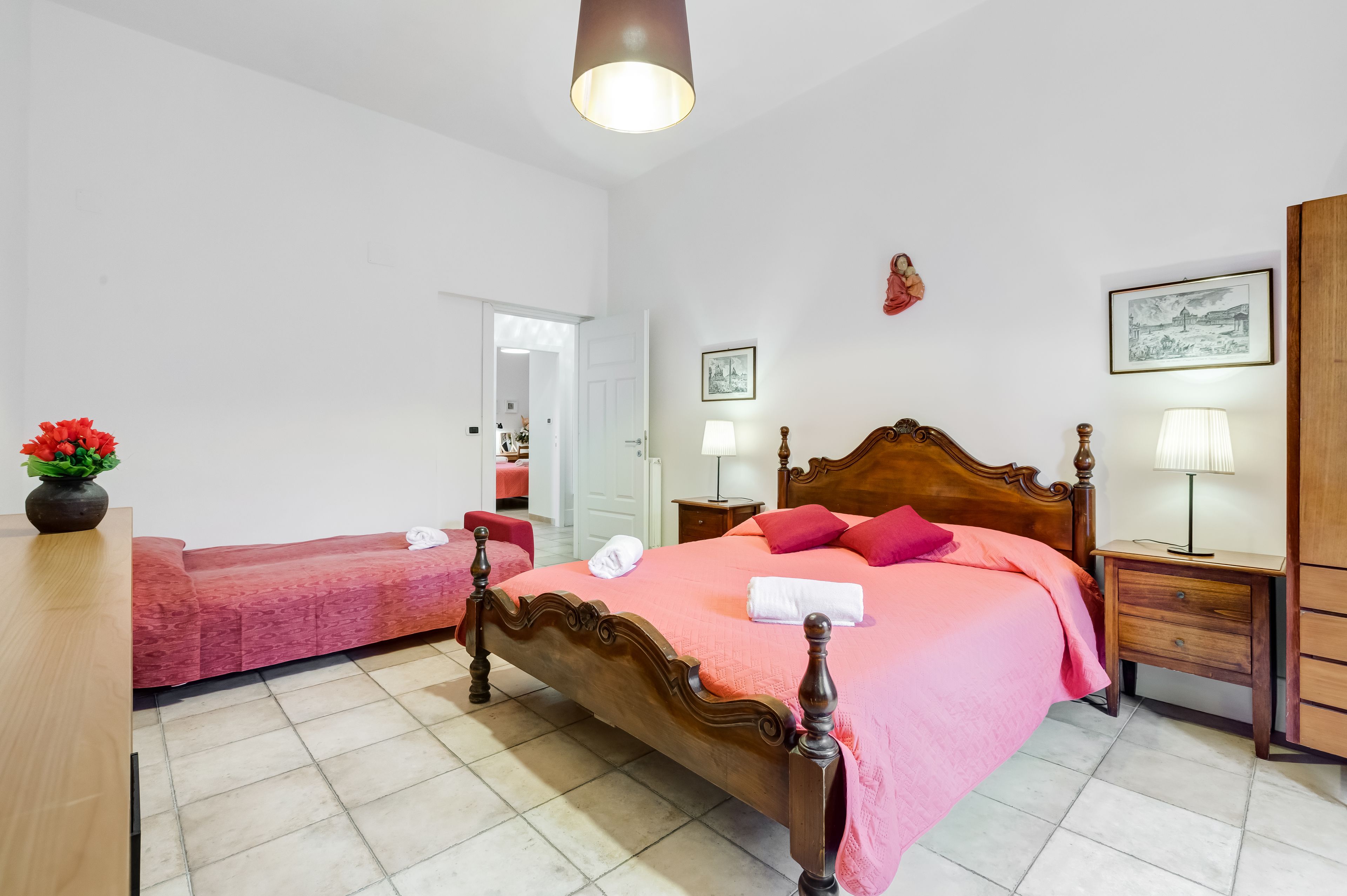 Un dormitorio con una cama de madera, una mesita de noche, una lámpara y una silla.