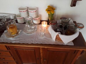A table with glassware, candles, and jars on a wooden cabinet. - Double Room (Type A) - Greber Christine - Frühstückspension Fernblick (Schoppernau)