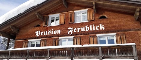 Una chaleta tradicional con un letrero que dice 'Pension Fernblick'.
