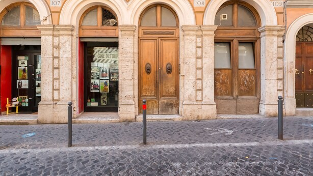 A building with arched windows and doors, numbered 107, 108, and 109. - Monti Colosseum Apartment-Urbana (Rome)