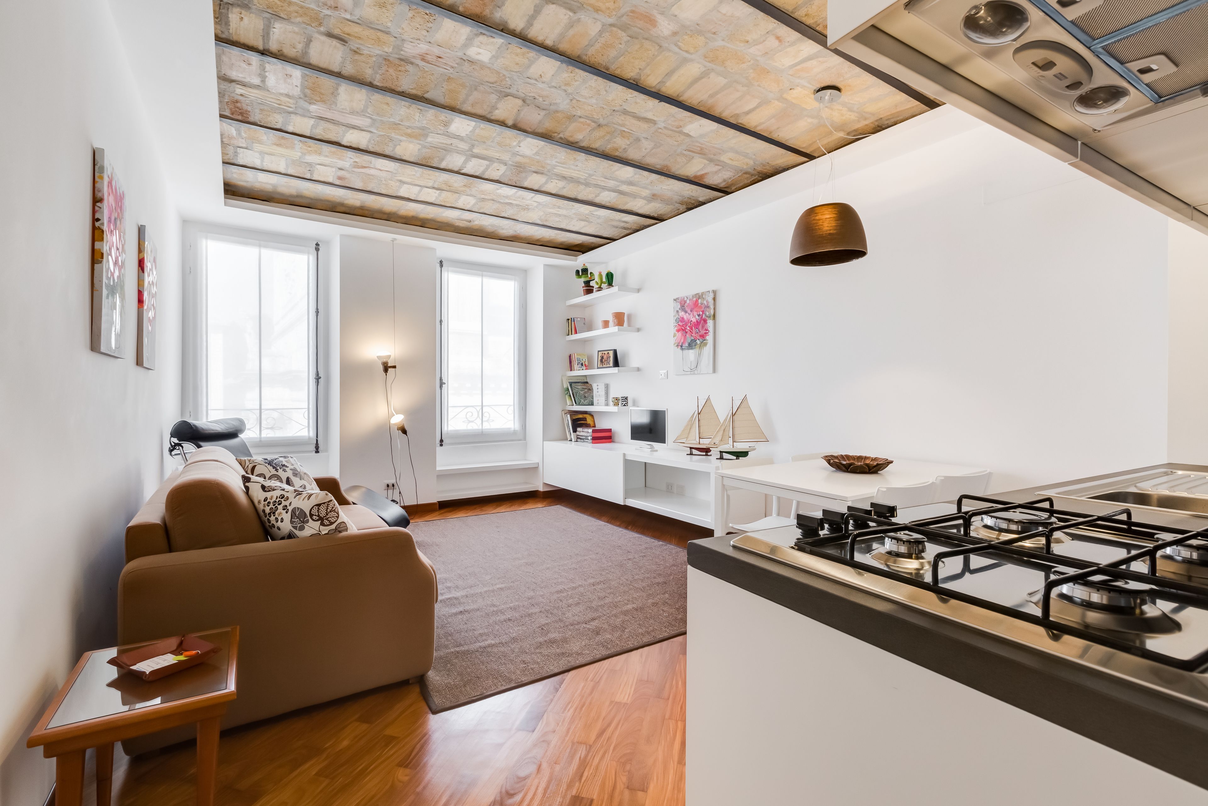 A modern apartment with a kitchen, living area, and a large window.