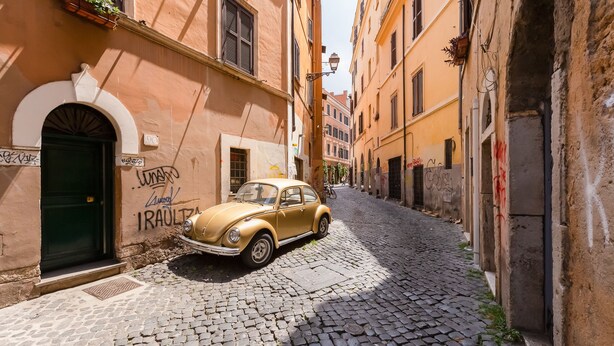 A narrow cobblestone street with a vintage car parked on the side. - Romantic House in Trastevere (Rome)