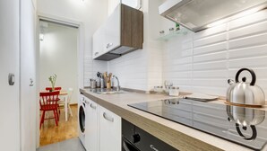 Una cocina moderna con lavavajillas integrado, hervidor y fregadero.