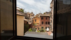 A view from a window of a narrow street with buildings, some with satellite dishes and balconies. - Pellegrino Campo de' Fiori Suite (Rome)