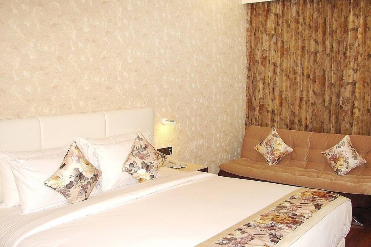 Ein Hotelzimmer mit einem großen Bett, einer Couch und einer Wand mit strukturierter Oberfläche.