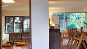 Ein modernes Wohnzimmer mit großem Fenster, Kamin und Essbereich mit Holzmöbeln.