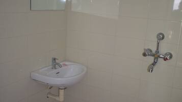 A bathroom with a white sink, a toilet, and a shower.