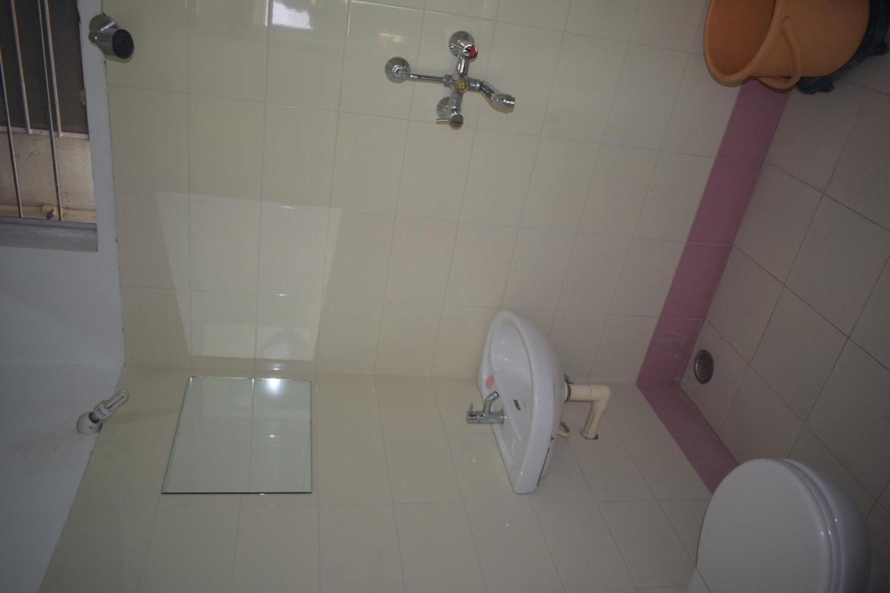 A bathroom with a toilet, a bidet, and a showerhead.