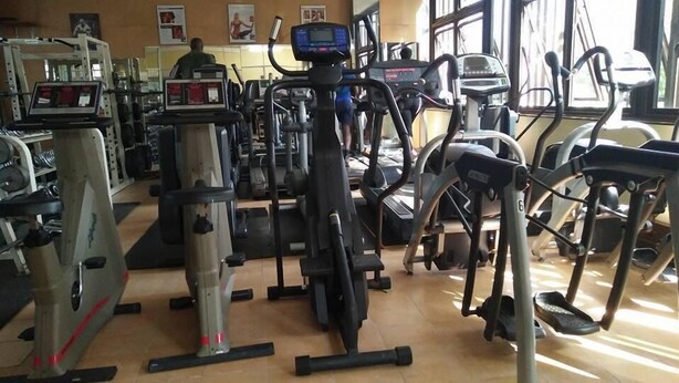 A gym with various exercise equipment including treadmills, stationary bikes, and elliptical machines. - Racecourse Inn Hotel (Eldoret)