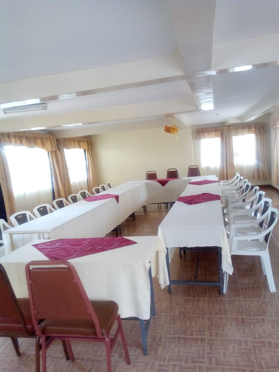 Un salón de conferencias con varias mesas y sillas dispuestas en filas.