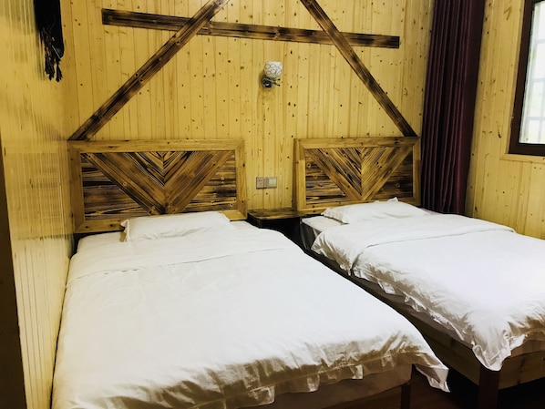 A room with two beds, wooden walls, and a window with curtains. - one step to heaven inn (Zhangjiajie)