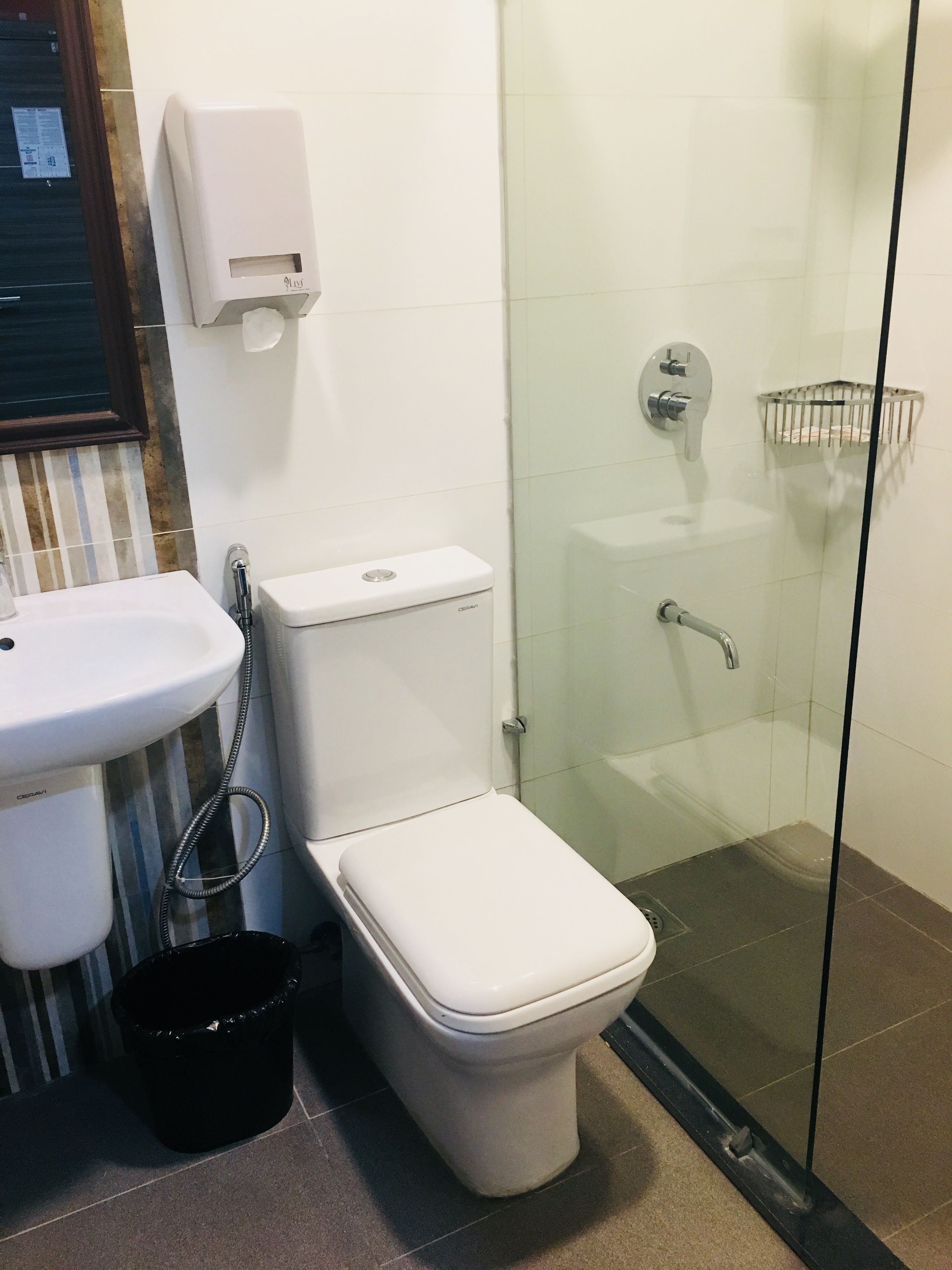 A bathroom with a toilet, sink, and shower.