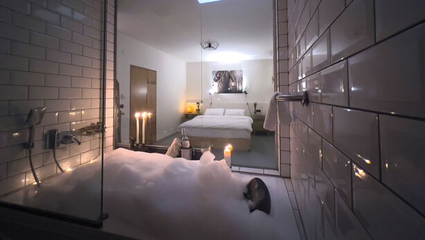 Un baño moderno con una bañera grande, zona de ducha y tragaluz.