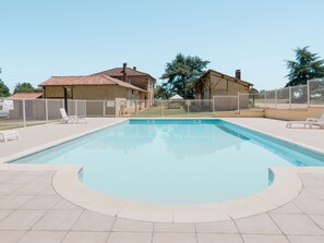 Una piscina al aire libre, tumbonas