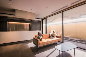 Eine moderne Küche mit Backofen, großem Fenster und einer Sitzecke mit Glastisch.