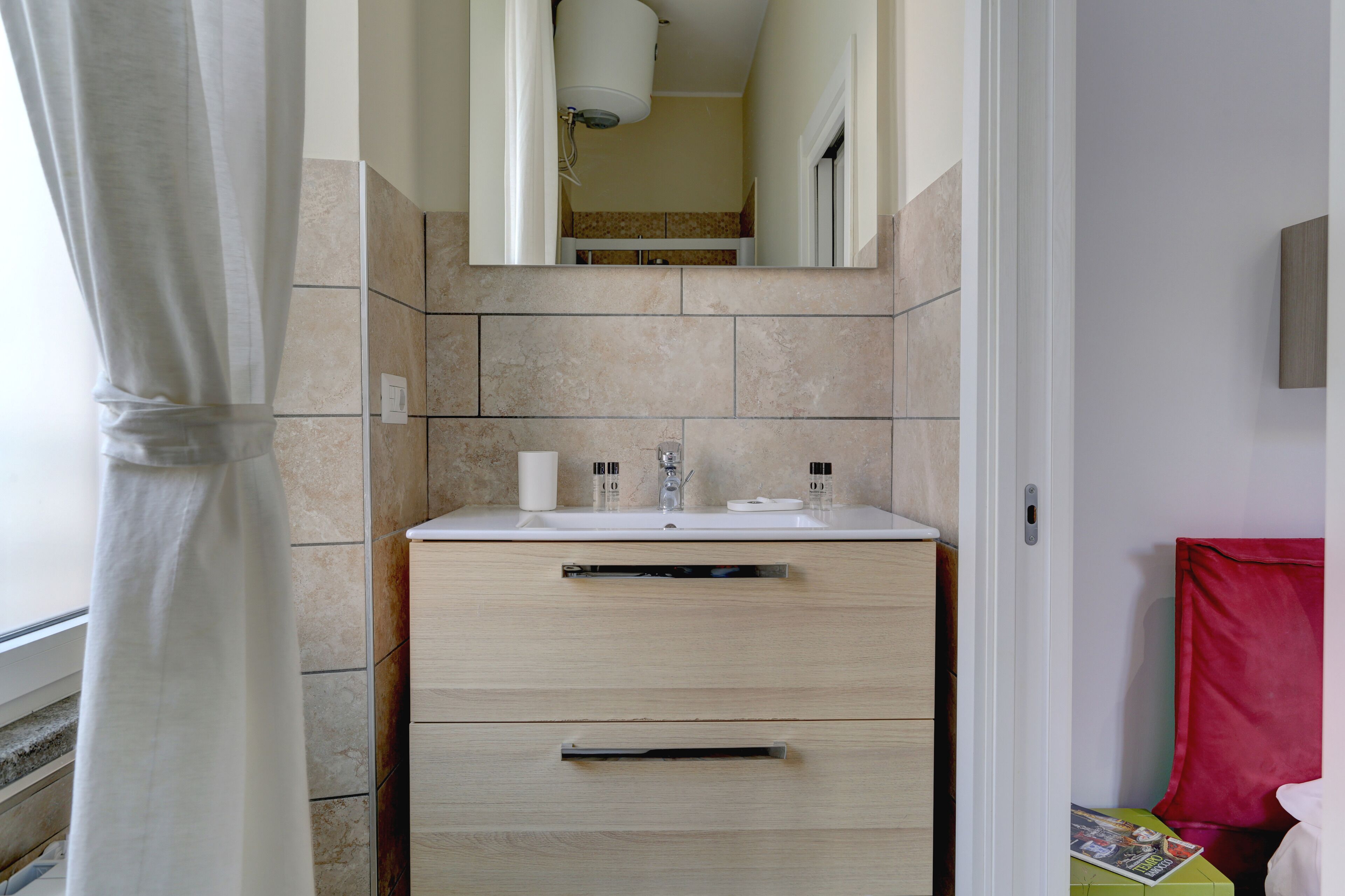 Une salle de bain équipée d’un lavabo, d’un miroir et d’un porte-serviettes.