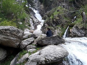A natural setting with a waterfall, large rocks, and greenery. - Double room max. 2P - Greber Christine - Frühstückspension Fernblick (Schoppernau)