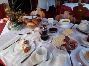 A breakfast table with bread, pastries, cheese, ham, and a coffee pot. - Double room max. 2P - Greber Christine - Frühstückspension Fernblick (Schoppernau)