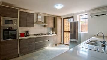 Villa de lujo (4 Suites Luxe) | Cocina privada | Frigorífico, microondas (previa solicitud), horno y placa de cocina