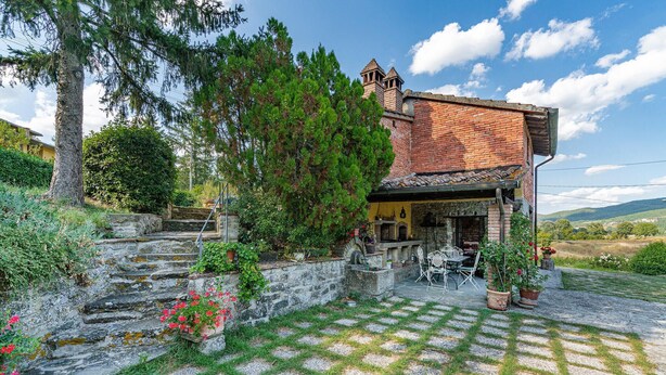 A rustic stone house with a brick chimney, a stone staircase, and a patio with outdoor seating. - Awesome home in Arezzo -AR- with WiFi (Arezzo -AR-)