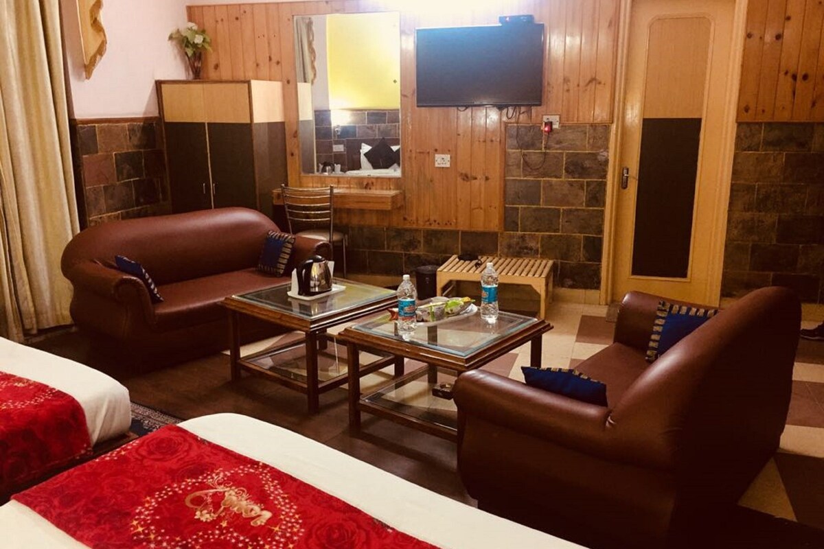 Una habitación acogedora con pared de madera, televisor de pantalla plana, chimenea, sofá y mesa de centro.