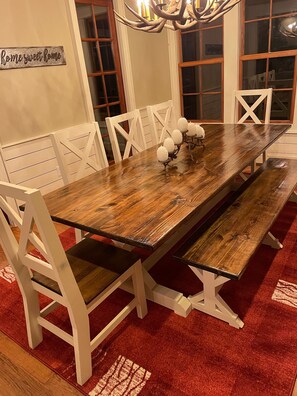 A dining table with white chairs, a chandelier, and a red carpet. - Extra Lg 4 Bed & 5 1/2. BA, Great for families & couples! (Highlands)