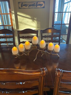 A dining table with six candles on a branch-style holder, wooden chairs around it, and a 'Home sweet home' sign on the wall. - Extra Lg 4 Bed & 5 1/2. BA, Great for families & couples! (Highlands)